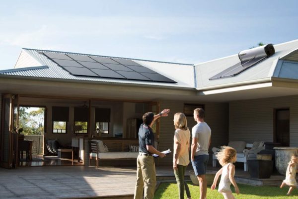 Solahart solar consultant with family inspecting solar system